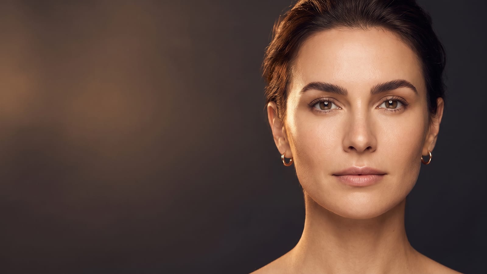 Elegant woman facing the camera with beautifully shaped, defined eyebrows — comparing microblading, powder brows and ombré in Highland Park