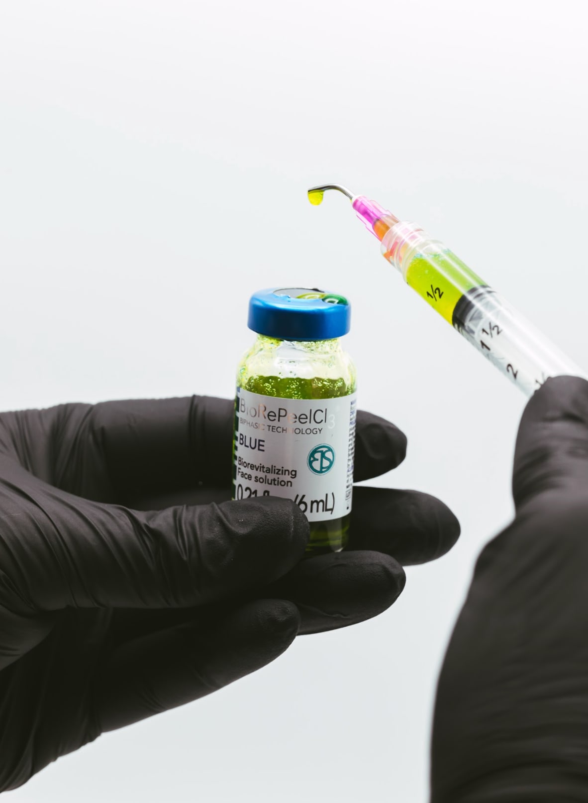 Gloved hand holding a vial of BioRePeelCl3 BLUE at DK Aesthetics in Highland Park, IL